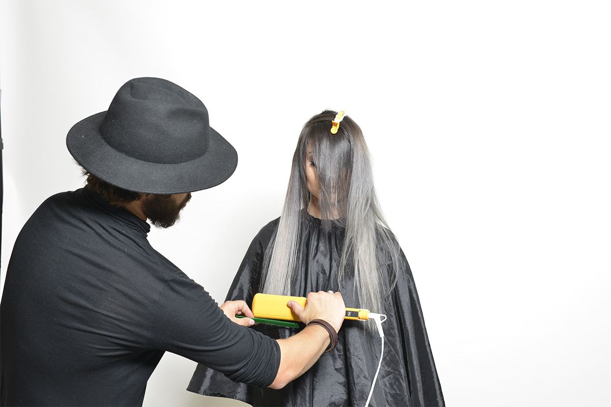 Stylista Kuźni Fryzjerskiej Jewuła podczas prostowania włosów